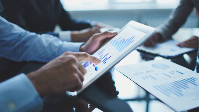 Businesspeople reading report on tablet