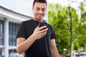 Hispanic man engaging with local community bank using mobile device