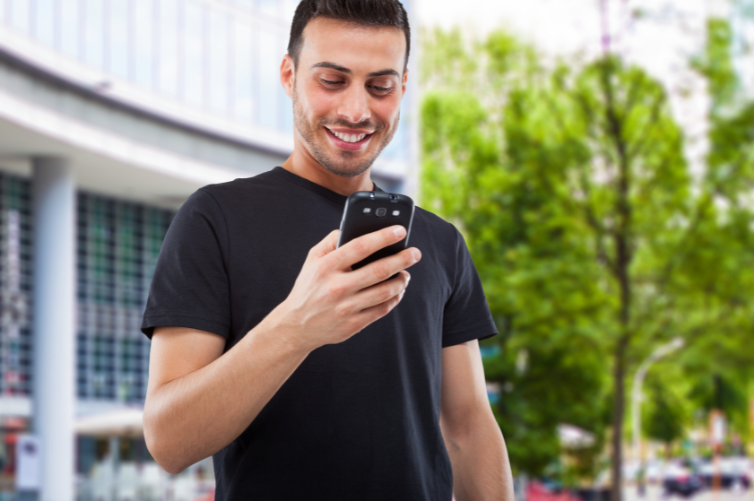Hispanic man engaging with local community bank using mobile device
