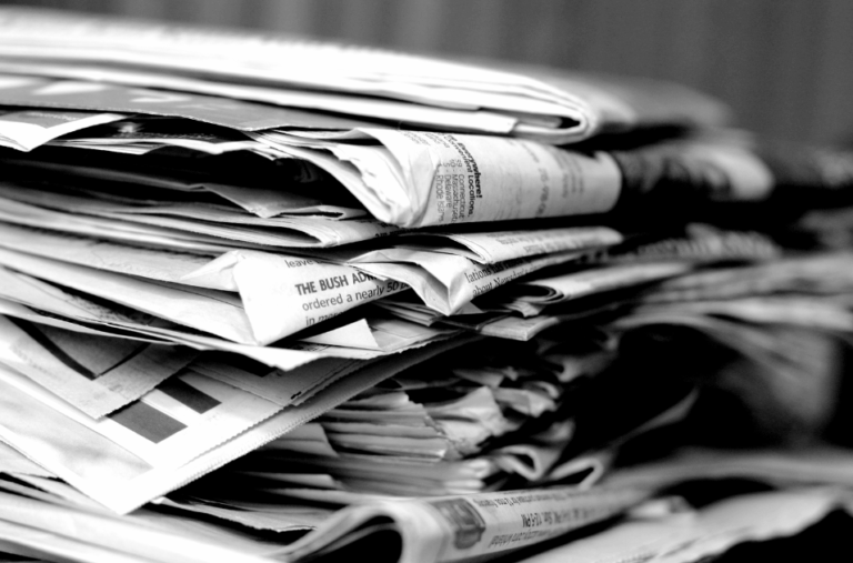 Stack of newspapers symbolizing decline of traditional bank branches in the digital age