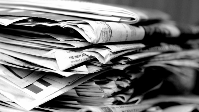 Stack of newspapers symbolizing decline of traditional bank branches in the digital age